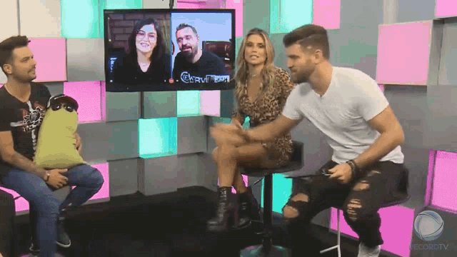 a group of people are sitting in front of a screen that says record tv