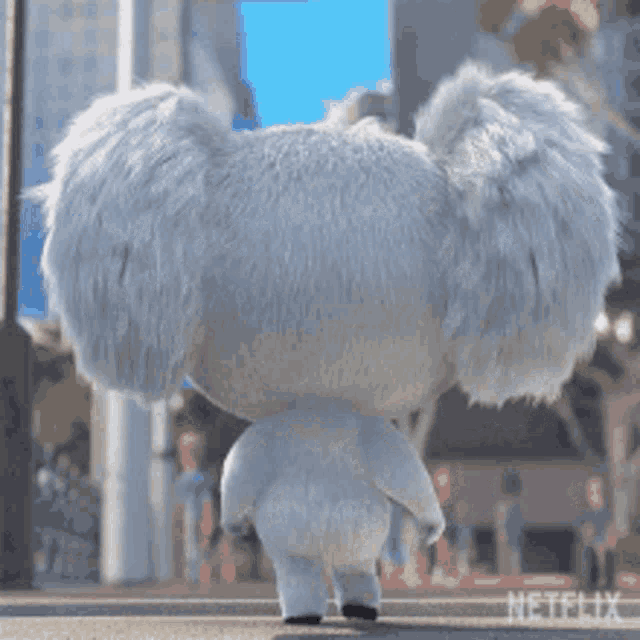 a stuffed koala bear is walking down a sidewalk .