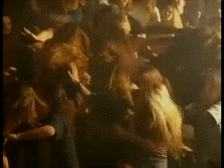 a blurry picture of a crowd of people dancing in a dark room