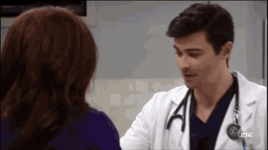 a man in a lab coat with a stethoscope is talking to a woman