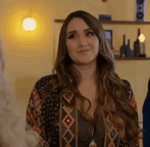 a woman with long hair is smiling and looking at the camera in a room .