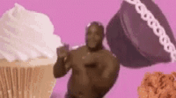a man is dancing in front of a cupcake , cake , and fried chicken .