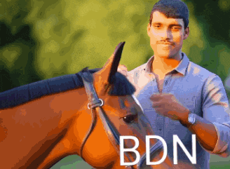 a man standing next to a horse with the word bdn on the bottom right