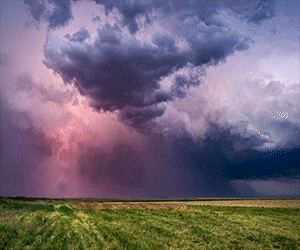 a stormy sky with purple and pink clouds and lightning