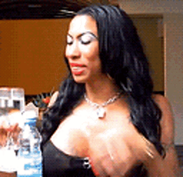 a woman is holding a bottle of water in her right hand