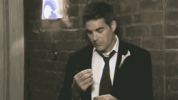 a man in a suit and tie with a yellow flower on his lapel