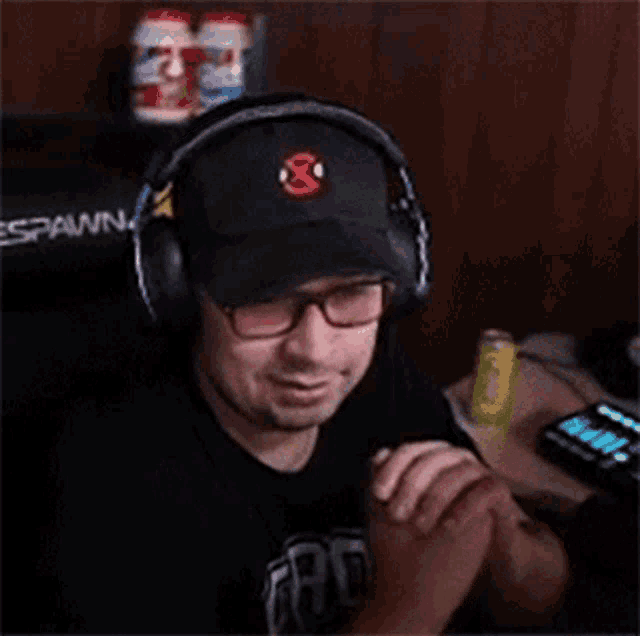 a man wearing headphones and a hat is playing a video game while holding a controller .