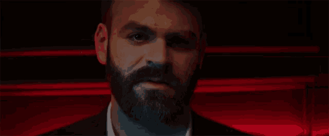 a man with a beard wearing a suit and white shirt