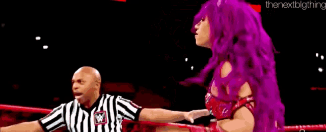 a woman with pink hair is standing next to another woman with pink hair .