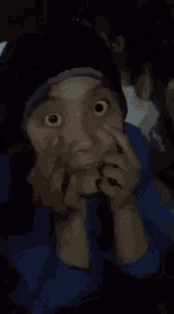 a blurry picture of a person making a funny face with their hands