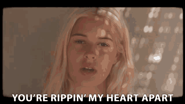 a woman singing a song with the words " you 're rippin ' my heart apart " at the bottom