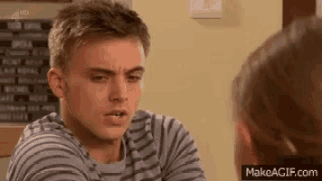 a man in a striped shirt is looking at a woman .