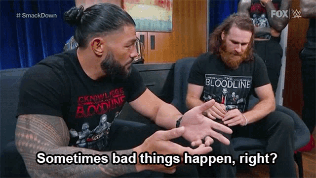 two wrestlers are sitting on a couch and one of them is wearing a shirt that says bloodline