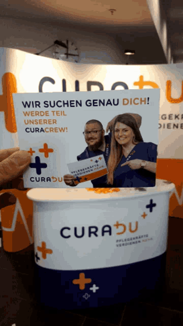a man holds up a card that says wir suchen genau dich
