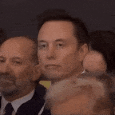 a man in a suit and tie is looking up at something