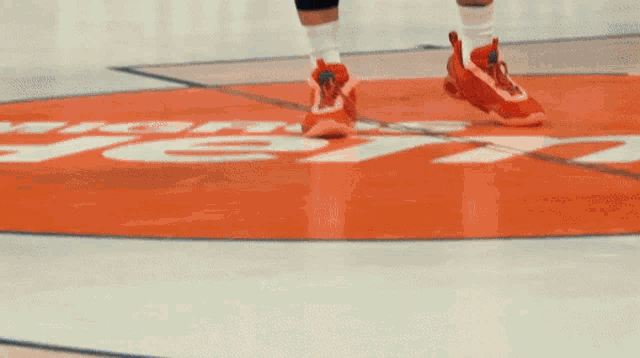 a person 's feet are on a basketball court with the word jets on it