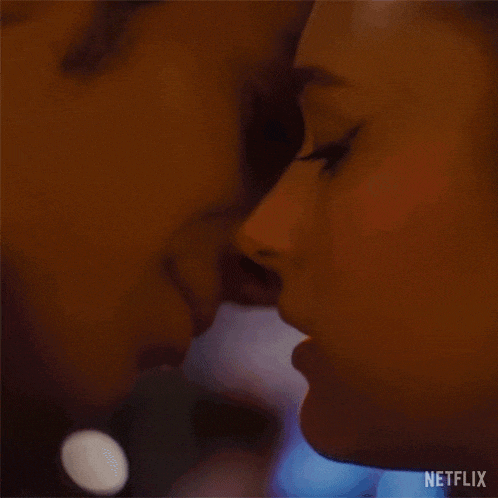 a close up of a man and a woman kissing each other .