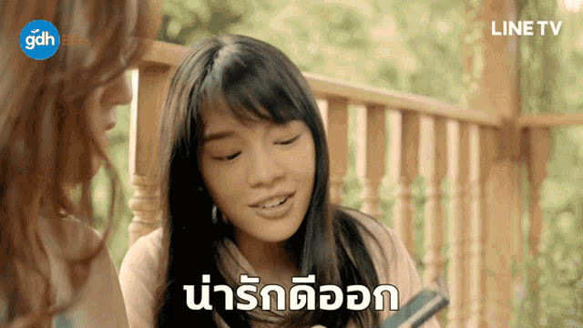 a woman sitting on a porch with a line tv logo on the bottom