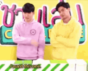 two young men are standing next to each other with their arms crossed and one of them is saying i want this one .
