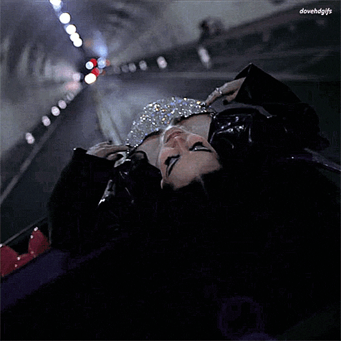 a woman is laying on her back in a dark tunnel with the words dovehdgfs above her