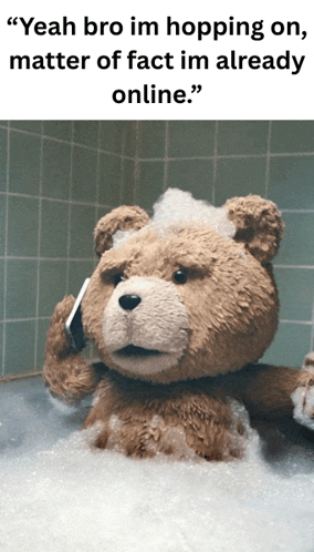 a teddy bear is talking on a cell phone in a bath tub