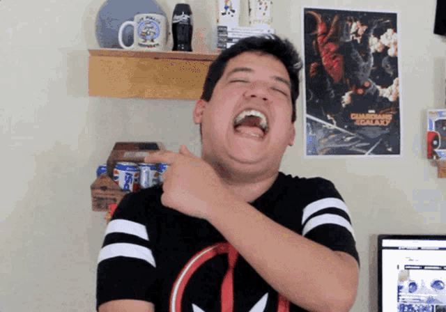 a man laughs in front of a poster for star wars the galaxy