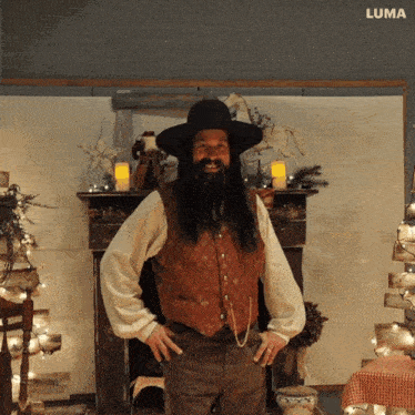 a man with long hair and a beard wearing a cowboy hat and vest