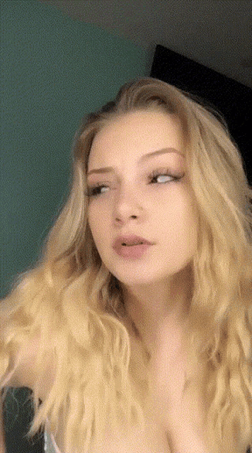 a woman with blonde hair looks at the camera with a serious look on her face