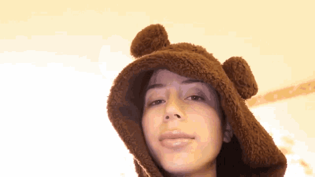 a woman wearing a brown hat with bear ears on it