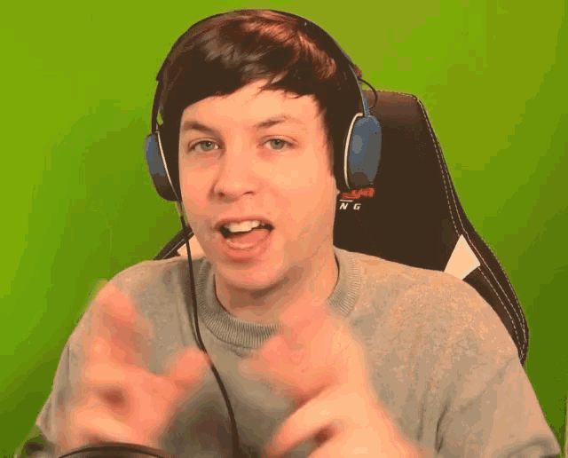 a man wearing headphones with the word gaming on the back of his chair
