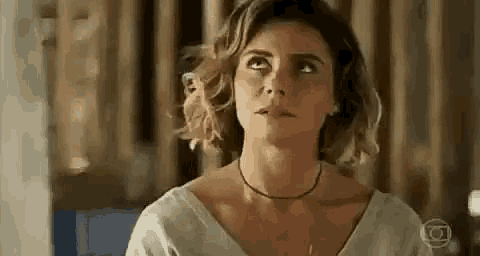 a close up of a woman wearing a choker necklace and a white shirt .