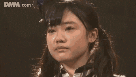 a close up of a woman 's face with a tear coming out of her eye .