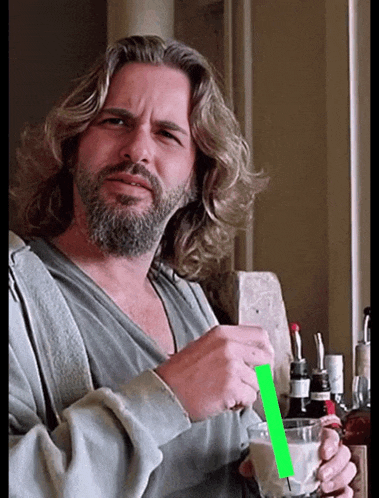 a man with long hair and a beard is holding a glass and a green straw