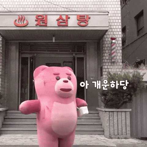 a pink teddy bear stands in front of a building that says ' a ' on it