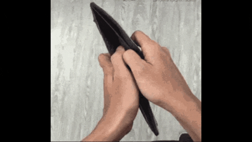 a person is holding a black wallet in their hands
