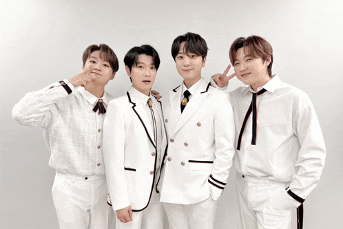 a group of young men wearing white suits and ties pose for a photo