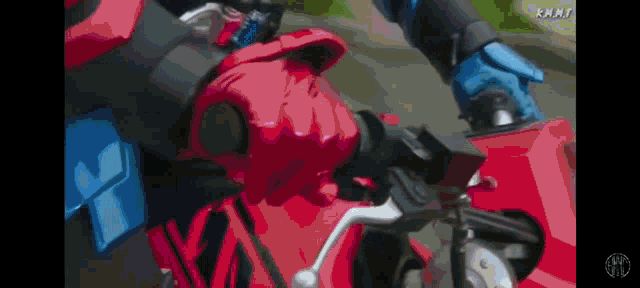 a person is riding a red motorcycle with a blue h on the side .