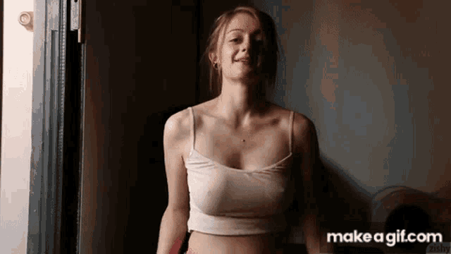 a woman in a crop top is standing in a doorway .