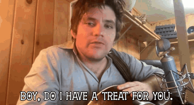 a man playing a guitar with the words boy do i have a treat for you above him