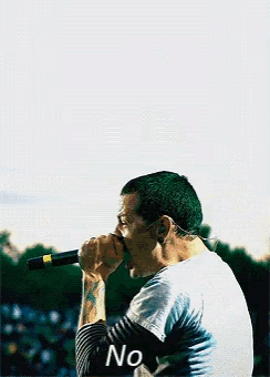 a man singing into a microphone with the word no on the bottom right