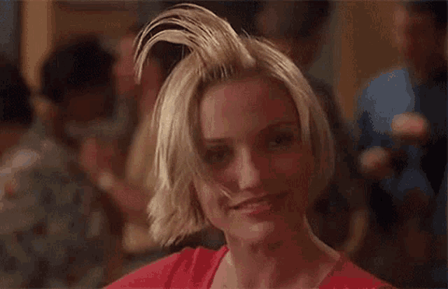 a woman with short blonde hair is making a funny face .