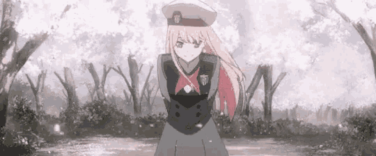 a girl with pink hair and a hat is standing in front of a forest .