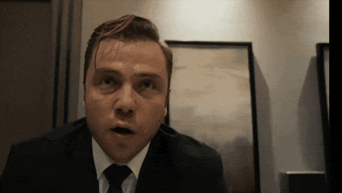 a man in a suit and tie is making a funny face