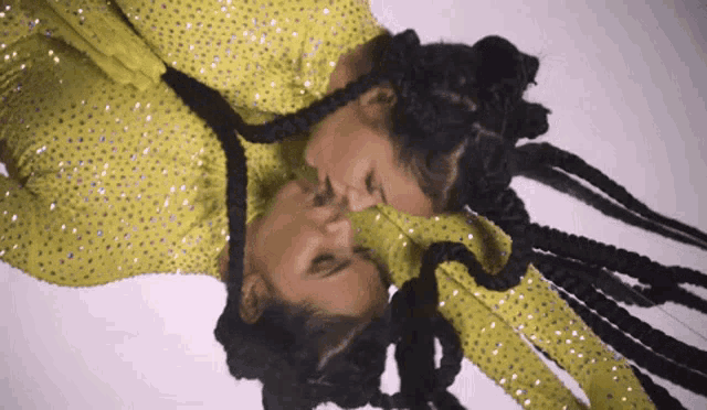 a woman in a yellow dress is kissing her reflection