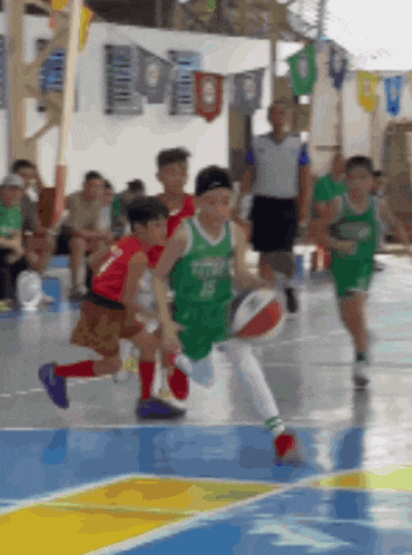 a group of young boys are playing basketball on a court and one of them has the number 15 on his jersey