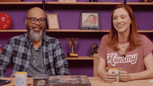a man and a woman are sitting at a table with a mug that says good morning america on it