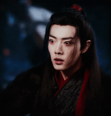 a man with long hair and a red scarf around his neck