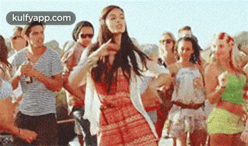 a woman is dancing in front of a group of people .