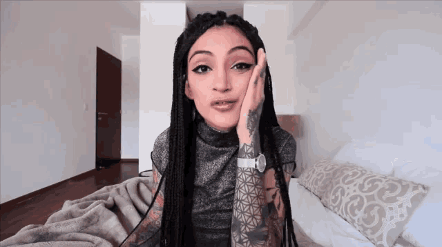 a woman with braids has a tattoo on her arm that says ' i 'm sorry '