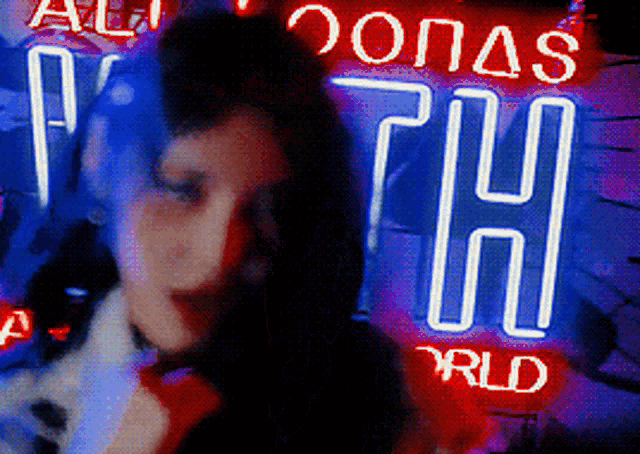 a woman stands in front of a neon sign that says ' zones th world '